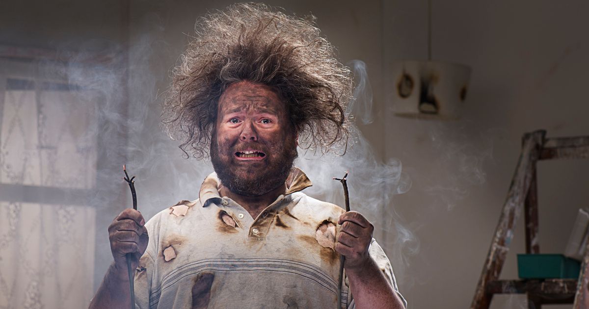 Uomo con i capelli elettrizzati dopo un lavoro elettrico fai da te